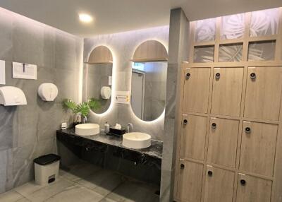 Modern bathroom with dual sinks and lockers