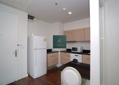 Modern kitchen with light wood cabinets and appliances