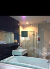 Modern bathroom with glass shower enclosure and white bathtub