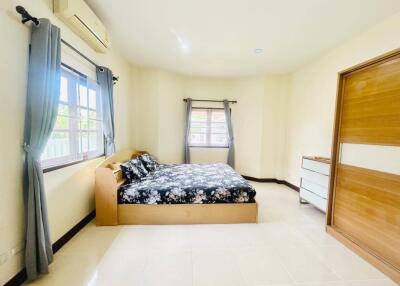 Spacious and bright bedroom with large windows and a comfy bed