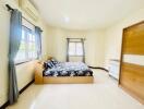 Spacious and bright bedroom with large windows and a comfy bed