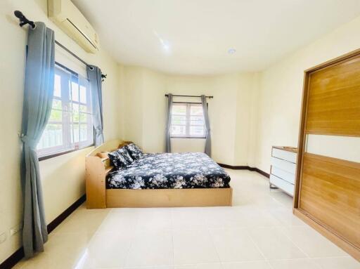 Spacious and bright bedroom with large windows and a comfy bed