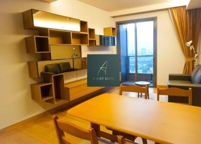 Modern living room with wooden dining table and wall-mounted shelving