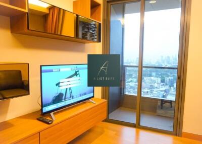 Living room with television and large glass door to balcony