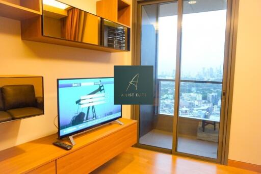 Living room with television and large glass door to balcony