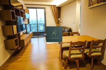 Modern living room and dining area with wall-mounted TV and city view