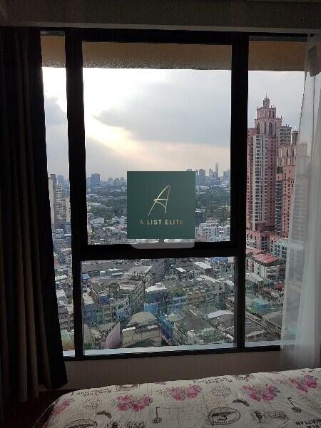 Bedroom with a large window offering a city view