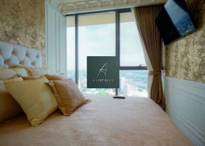 Elegant bedroom with a large window providing a scenic view, featuring a mounted TV and stylish decor.