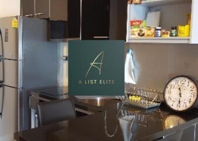 Modern kitchen with sleek black cabinetry, breakfast bar, and stainless steel appliances