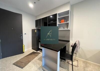 Modern kitchen with black cabinetry and a small bar