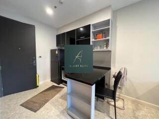 Modern kitchen with black cabinetry and a small bar