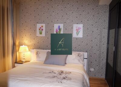 Cozy bedroom with bedside lamp and floral wall art