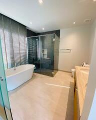 Modern bathroom with a bathtub, glass shower, and double sink vanity