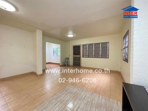 Spacious living room with tiled flooring and large windows