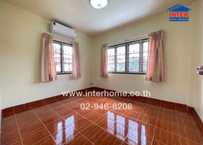 Empty bedroom with tiled floor, curtains, and air conditioning unit.