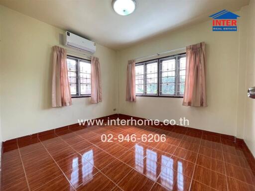 Empty bedroom with tiled floor, curtains, and air conditioning unit.