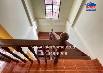 Staircase with wooden railing and window with bars