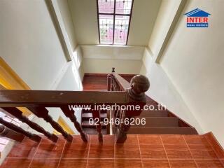 Staircase with wooden railing and window with bars