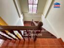 Staircase with wooden railing and window with bars