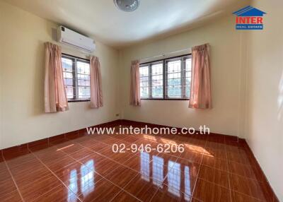 Empty bedroom with two windows and air conditioning unit