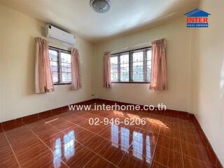 Empty bedroom with two windows and air conditioning unit