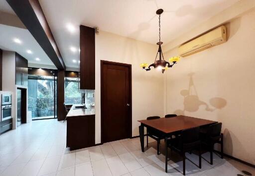 Modern kitchen and dining area with table, chairs, and built-in appliances