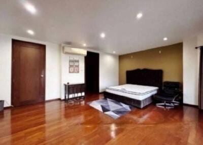 Spacious bedroom with wooden flooring, ceiling lights, and a double bed