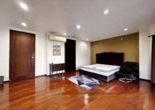 Spacious bedroom with wooden flooring, ceiling lights, and a double bed