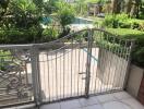 Outdoor area with pool view and metal gate