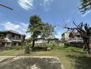 Spacious backyard with trees and neighboring houses