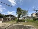 Spacious yard with trees and surrounding houses