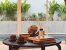 Coffee table with books, candles, and cups with view of garden