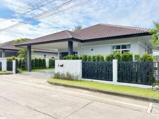 Exterior view of a modern single-story home with a tiled roof and landscaping