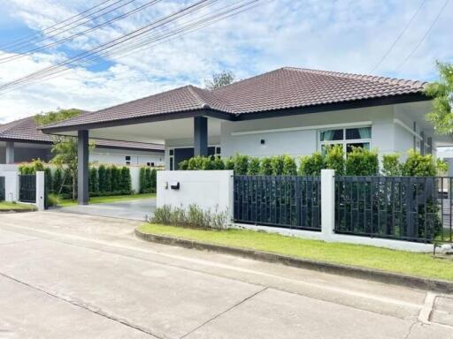 Exterior view of a modern single-story home with a tiled roof and landscaping