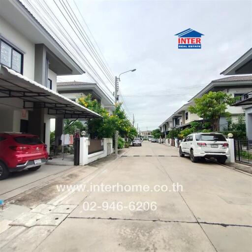 Street view of residential neighborhood with modern houses and parked cars