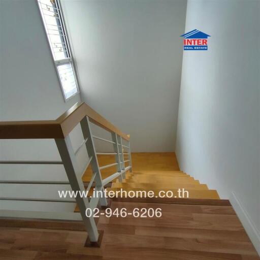 Staircase with wooden steps and white walls