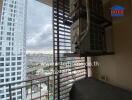 City view from a balcony with nearby high-rise buildings and air conditioning units