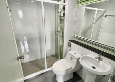 Modern bathroom with glass shower enclosure, toilet, and sink