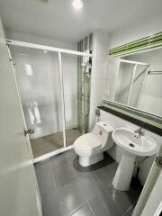 Modern bathroom with glass shower enclosure, toilet, and sink