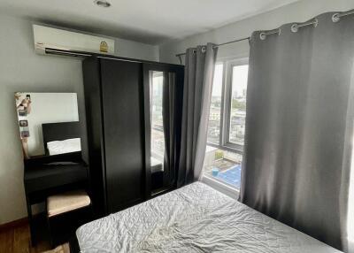 A modern bedroom with a large window, wardrobe, vanity table, and double bed.