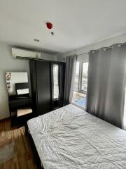 A modern bedroom with a large window, wardrobe, vanity table, and double bed.