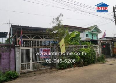 Exterior view of a residential house with a gated front yard.