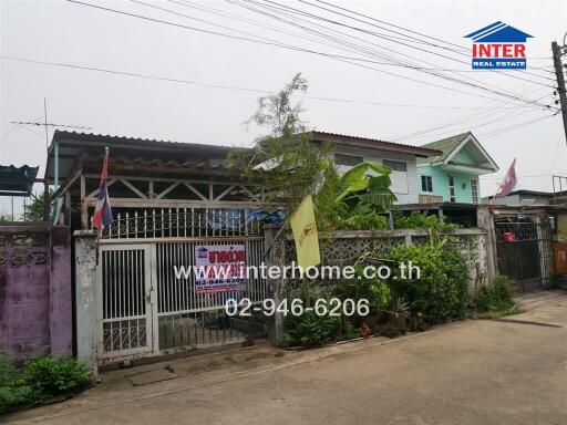 Exterior view of a residential house with a gated front yard.