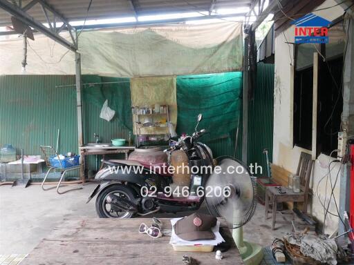 Garage area with motorcycle and various stored items