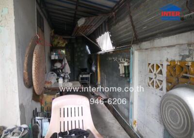 Outdoor utility area with a chair and household items