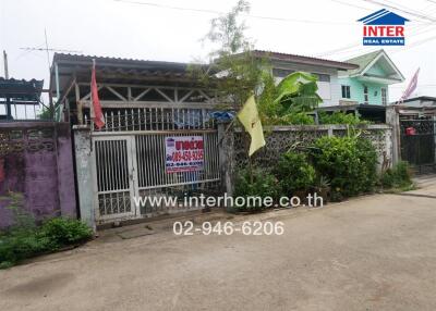 Exterior view of the property with front gate and garden areas