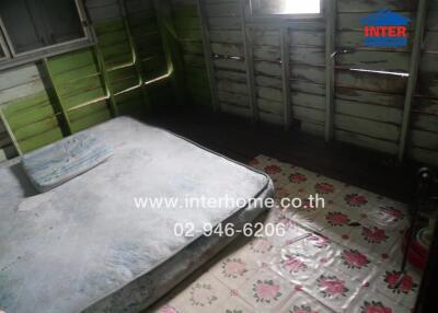 Bedroom with old mattress and wooden walls