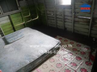 Bedroom with old mattress and wooden walls