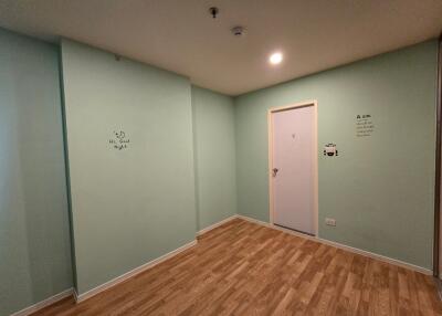 Simple bedroom with wooden floor and green walls