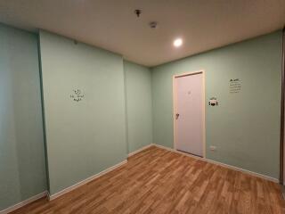 Simple bedroom with wooden floor and green walls